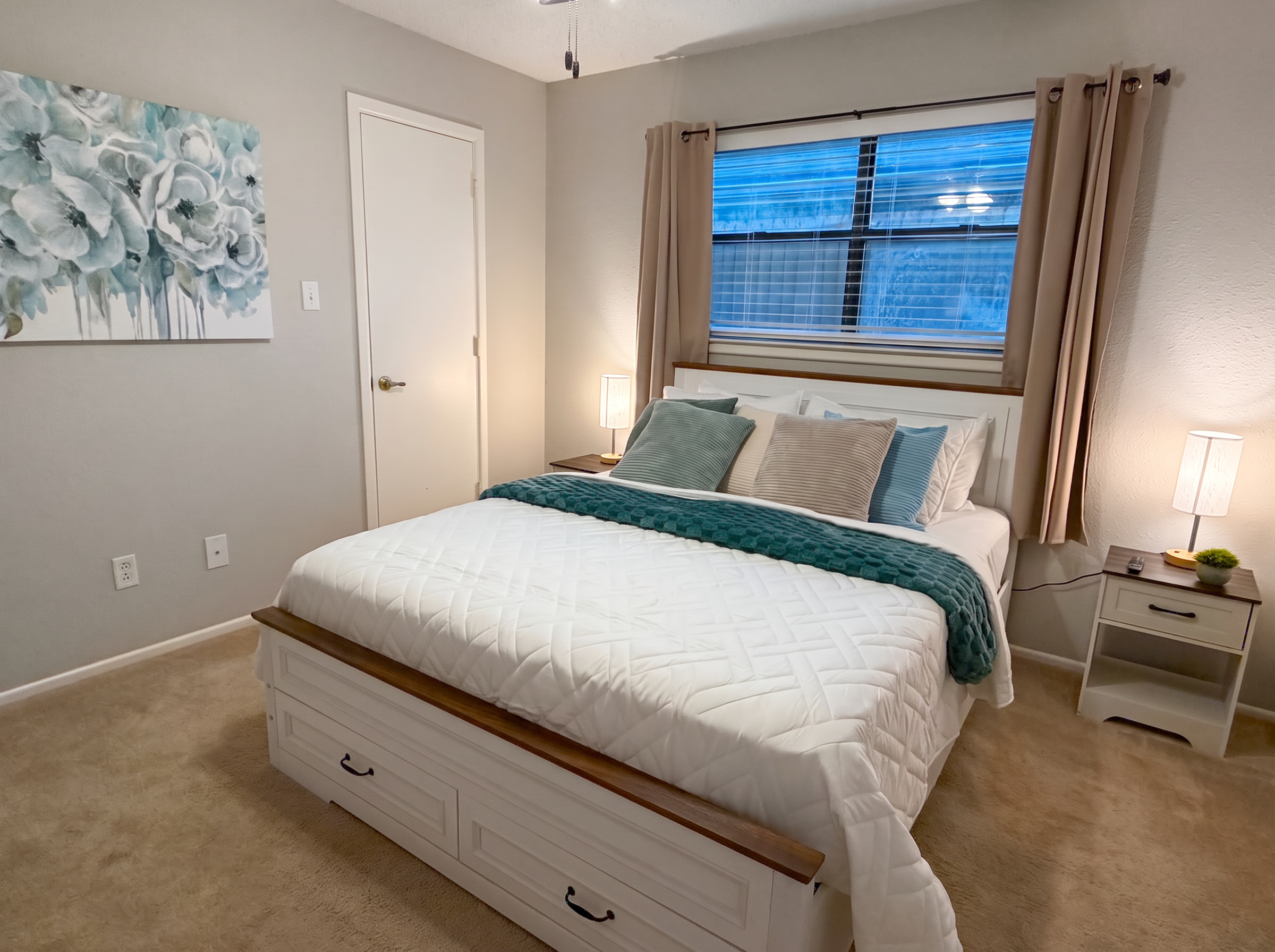 Guest bedroom with queen bed and soft teal accents